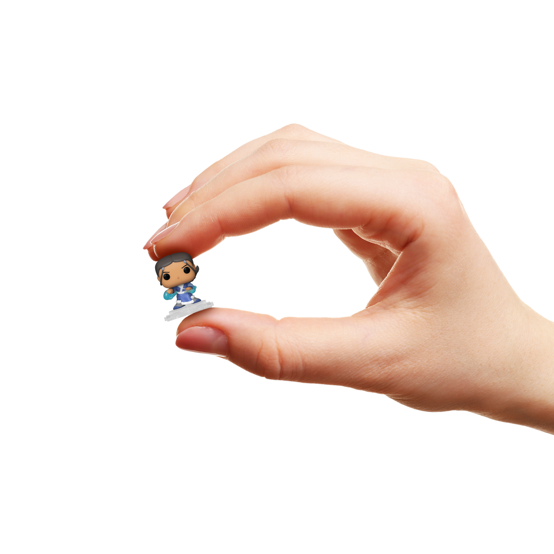 Hand holding a small figurine against a white background